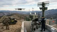 Poste de surveillance frontalier équipé de radars et de drones illustrant la défense territoriale moderne.