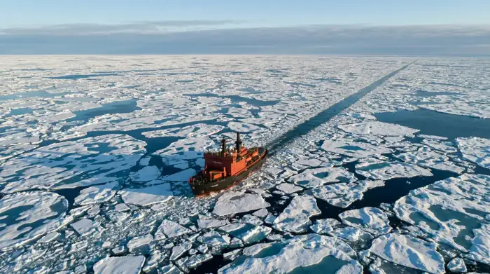 Banquise arctique fracturée vue du ciel, traversée par un brise-glace.
