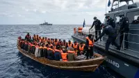 Garde-frontières européens et embarcation de migrants en Méditerranée, illustrant l'enjeu migratoire pour l'Union européenne.