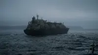 Méthanier traversant un détroit maritime sous faible visibilité, transpondeur éteint, mer sombre au crépuscule.
