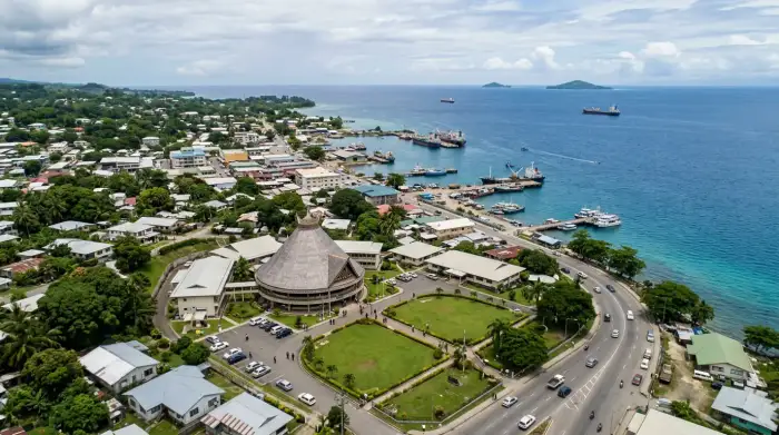 Vue aérienne de Honiara, capitale des Îles Salomon, avec le Parlement au premier plan et le Pacifique Sud en arrière-plan.