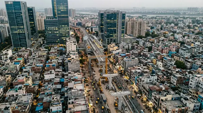 Vue aérienne d'une ville indienne mêlant gratte-ciel modernes, chantiers de métro et quartiers denses