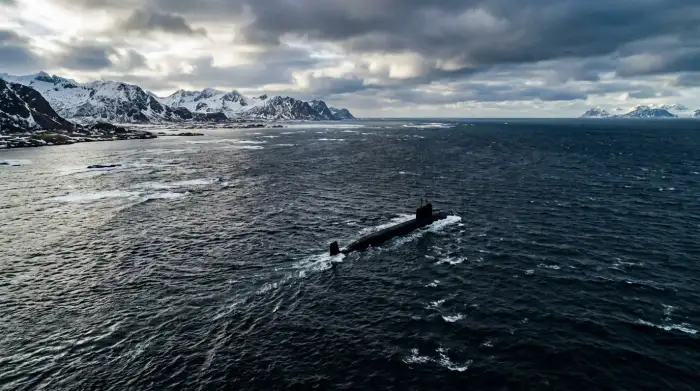 Vue aérienne de la mer de Barents entre l'île aux Ours et la Norvège, sous ciel arctique, avec silhouette de sous-marin en plongée