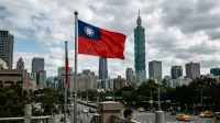 Drapeau de Taïwan flottant devant les gratte-ciels de Taipei, symbole d'une démocratie insulaire sous pression.