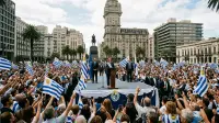 Cérémonie d'investiture présidentielle sur la Plaza Independencia de Montevideo, foule et drapeaux uruguayens devant le palais Salvo.
