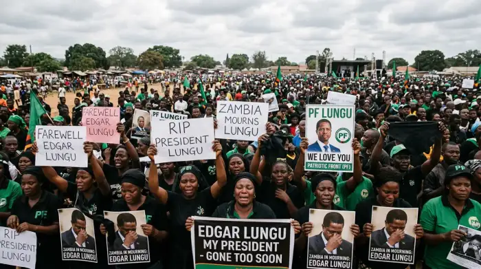 Une foule de partisans zambiens en deuil portant des affiches d'Edgar Lungu lors d'un rassemblement politique à Lusaka.